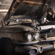 Finn Wolfhard's Trevor looks under the hood of a rusty Ecto-1 in Ghostbusters: Afterlife.